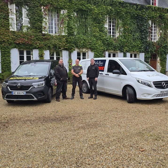 A branded Pest In Peace van with pest technicians in front of it